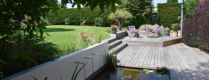 Aménagement de jardin thérapeutique avec terrasse en bois, fontaine murale et bassin zen